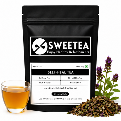 A black stand-up pouch of Sweetea Self-Heal Tea with a white label, shown on a white background with a glass of amber tea, loose dried tea leaves, and purple flowers.